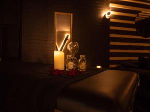 eine Kerze und ein Kerzenhalter auf einem Tisch in einem dunklen Raum in der Unterkunft Douceur du Charme - Love-room à Charmes entre Epinal et nancy in Charmes