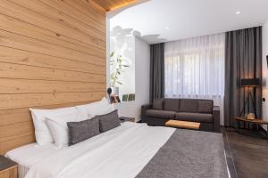 Boljevac的住宿－Hotel Ramonda，卧室配有一张白色的大床和一张沙发。