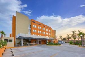 un edificio con un estacionamiento delante de él en City Express Plus by Marriott Cabo San Lucas, en Cabo San Lucas