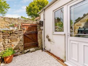 eine Tür zu einem Steingebäude mit einer Steinmauer in der Unterkunft 4 bed in North York Moors 82262 in Danby