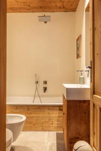 a bathroom with a tub and a toilet and a sink at Casa Alvera Dream in Cortina dʼAmpezzo