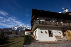 a building with a balcony with a mountain in the background at Casa Alvera Dream in Cortina dʼAmpezzo