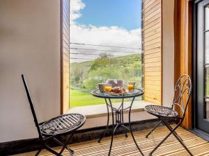 uma mesa e 2 cadeiras numa varanda com uma janela em 2 Bed in Skipton 83162 em Cononley