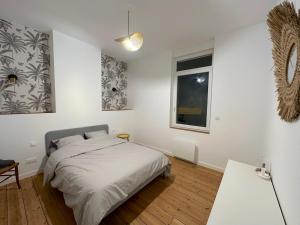 um quarto branco com uma cama e uma janela em L'Artoisienne • Parking sécurisé & Wifi fibre em Douai