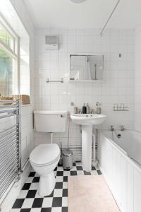 ein Badezimmer mit einem WC, einem Waschbecken und einer Badewanne in der Unterkunft Russell Square Vintage - 2 Cozy Bed Home in London