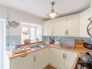 uma cozinha com armários brancos e um lavatório em 2 bed in Brixham 82723 em Brixham