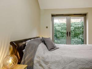 um quarto com uma cama e uma porta de vidro em 1 bed property in Huntingdon 83312 em Sawtry