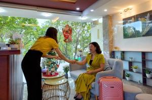 Sontra Sea Hotel في دا نانغ: اثنين من النساء واقفات في غرفة المعيشة