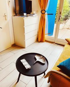 uma mesa de centro numa sala de estar com uma televisão em Maisonnette Provençal em Tourrettes