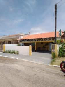 un bâtiment avec une clôture blanche à côté d'une rue dans l'établissement Brisa do Mar Guaratuba, à Guaratuba