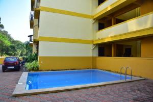 a swimming pool in front of a building at Fieldstone Lovely 2 BHK AC Apartment in Talaulim