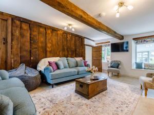 a living room with a blue couch and a wooden wall at 4 Bed in Hay-on-Wye 85357 in Michaelchurch Escley