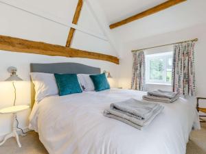 a bedroom with a large white bed with blue pillows at 4 Bed in Hay-on-Wye 85357 in Michaelchurch Escley