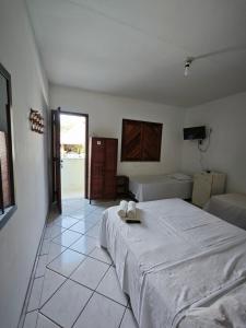 a bedroom with a large bed and a tiled floor at Pousada Villa Graciela in Ilhéus