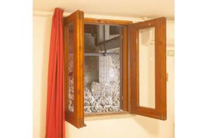 カンペーゼにあるLuisaの壁にガラス窓が付いた木製のキャビネット