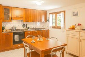 カンペーゼにあるLuisaのキッチン(木製キャビネット、木製テーブル付)