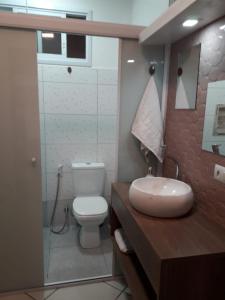 uma casa de banho com um WC branco e um lavatório. em LOFT NOVO CONFORTÁVEL em Sorocaba