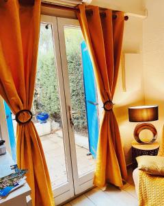 uma porta de vidro aberta com cortinas em frente em Maisonnette Provençal em Tourrettes