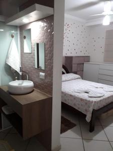 ein Bad mit einem Bett, einem Waschbecken und einem Spiegel in der Unterkunft LOFT NOVO CONFORTÁVEL in Sorocaba