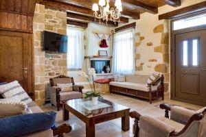 a living room with a couch and a table at Villa Kois by PosarelliVillas in Tzitzifés