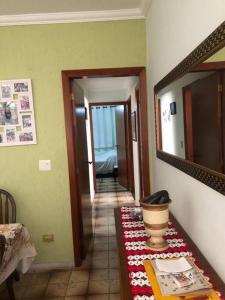 Pokój z przedpokojem ze stołem i lustrem w obiekcie Apartamento - Enseada Guarujá SP w mieście Guarujá