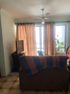 salon z kanapą i oknem w obiekcie Apartamento - Enseada Guarujá SP w mieście Guarujá