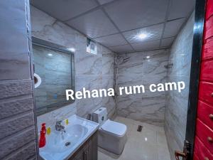 La salle de bains est pourvue d'un lavabo blanc et de toilettes. dans l'établissement Rehana rum camp, à Wadi Rum