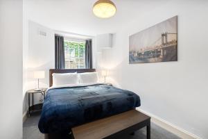 ein Schlafzimmer mit einem Bett und einem Bild an der Wand in der Unterkunft Russell Square Vintage - 2 Cozy Bed Home in London