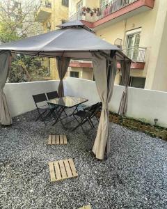 a table and chairs under an umbrella on a balcony at Family Apartment With Private Yard Next to Agios Dimitrios Church in Thessaloniki