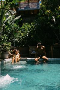 two people sitting in a swimming pool at Casa La Torre Hotel Boutique in Trancoso
