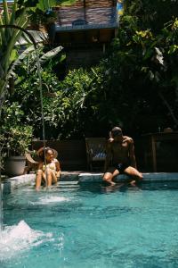 dos personas sentadas en una piscina en Casa La Torre Hotel Boutique, en Trancoso