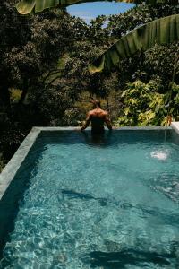 a man is standing in a swimming pool at Casa La Torre Hotel Boutique in Trancoso