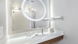a white bathroom with a sink and a mirror at SpringHill Suites by Marriott San Antonio Airport in San Antonio