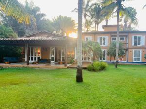 een huis met een palmboom in een tuin bij Suite de Luxo / Frente Mar / Serra Grande, Bahia (Luzimares) in Serra Grande
