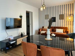 a living room with a table and a couch at Le Bouvault, style Appart'Hôtel , à Nevers proche Gare, services haut de gamme by PRIMO C0NCIERGERIE in Nevers