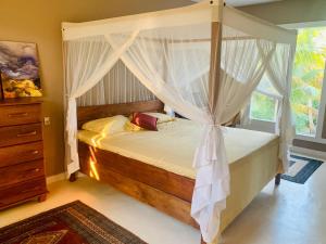 een slaapkamer met een hemelbed en een raam bij Suite de Luxo / Frente Mar / Serra Grande, Bahia (Luzimares) in Serra Grande