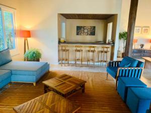 een woonkamer met een blauwe bank en een tafel bij Suite de Luxo / Frente Mar / Serra Grande, Bahia (Luzimares) in Serra Grande