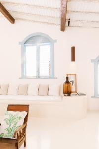 um quarto branco com um banco e uma janela em Casa La Torre Hotel Boutique em Trancoso