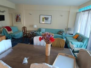 a living room with blue couches and a table with flowers at Mare e Monti1 in Kamena Vourla