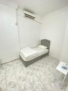 a white room with a bed and a table at Single bed hosted by dinar apartments in Abu Dhabi