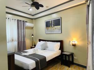 a bedroom with a bed and a ceiling fan at White Beach Front and Cottages in Buruanga