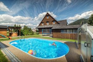 a house with a swimming pool in front of a house at Drevenica pod Sitieňom 1 in Lazisko