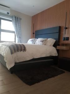 a bedroom with a large bed and a window at Sunset Retreat at Bay Point in Cape Town