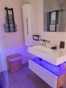 a white bathroom with a sink and a trash can at Sunset Retreat at Bay Point in Cape Town +14 photos