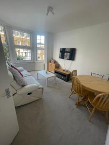 een woonkamer met een bank en een tafel bij Spacious 3 Bed Flat in Greenwich in Londen