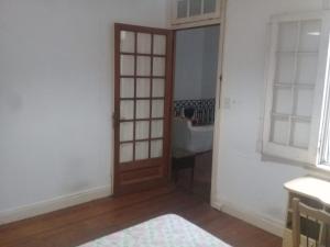 a room with a wooden door in a room at Habitac Indiv Casa de Familia, Flores in Buenos Aires