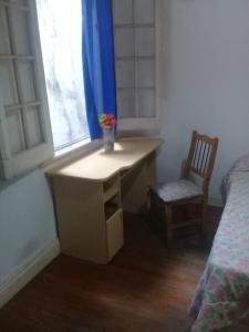 a desk in a bedroom with a chair and a window at Habitac Indiv Casa de Familia, Flores in Buenos Aires