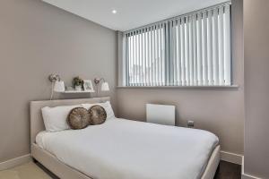 a bedroom with a white bed with two pillows on it at Apartments in Sheffield in Sheffield
