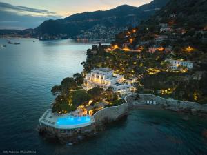 an aerial view of a resort in the water at night at Hotel Cap Estel in Èze