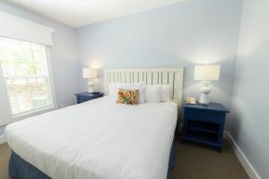 una camera con un letto bianco e due comodini di King's Creek Resort by Spinnaker a Williamsburg Altre 27 foto